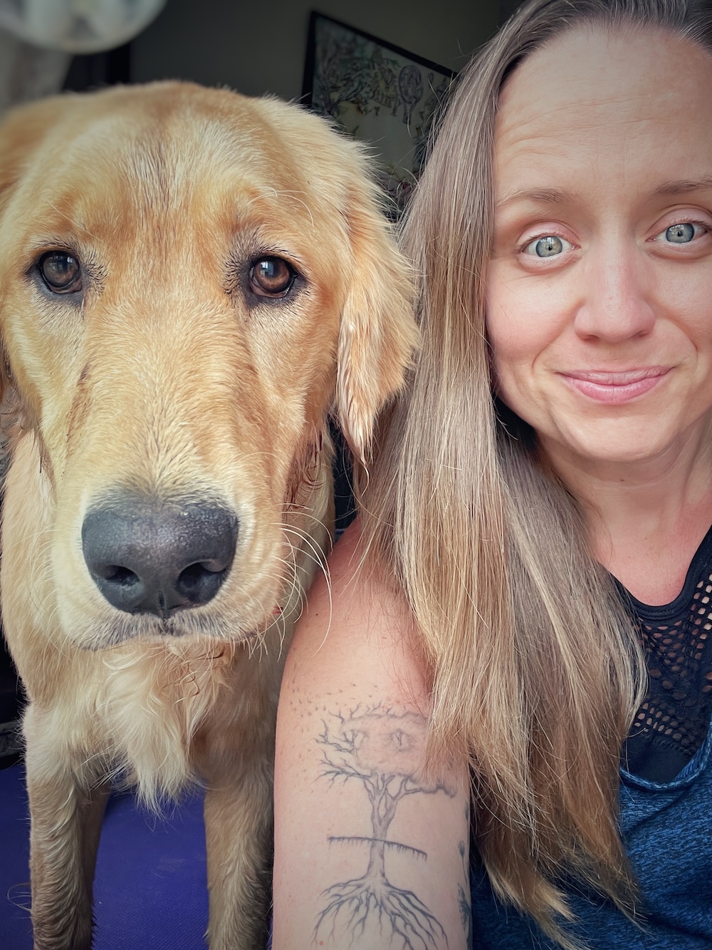Selfie of a woman and her golden retriever looking straight into the camera