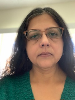 Headshot of a woman with dark hair and glasses 