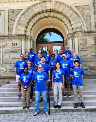 group of people with libretexts shirts in front of stone building steps