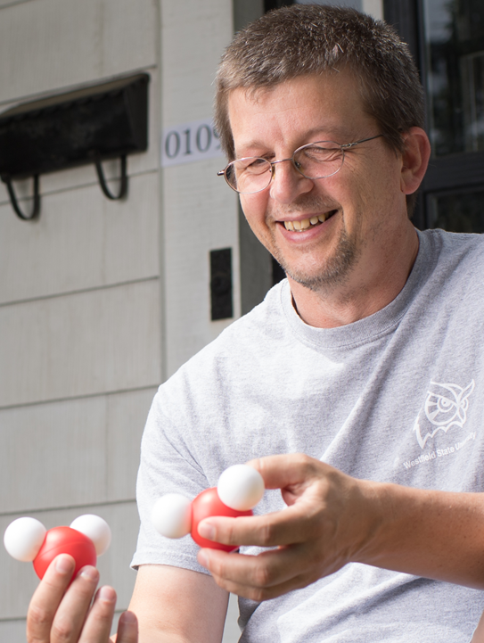 man smiling in front of a doorstoop